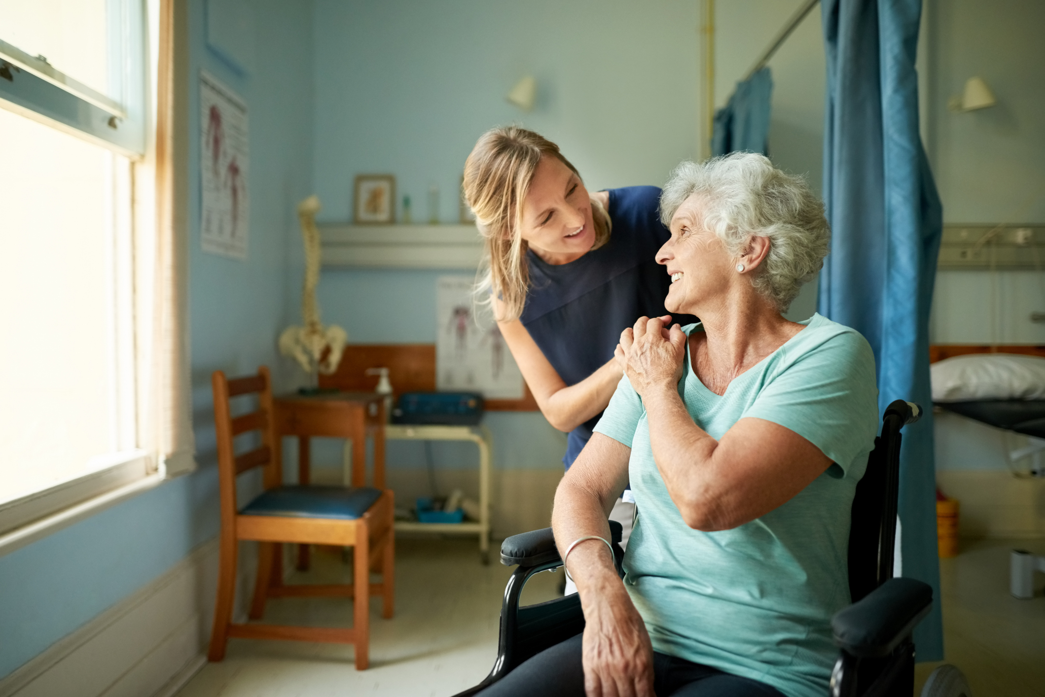 Caregiver assisting an elderly person in a wheelchair